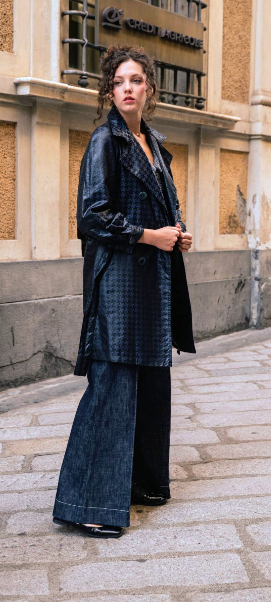 Vista laterale del trench sartoriale abbinato al pantalone sartoriale n denim blu scuro