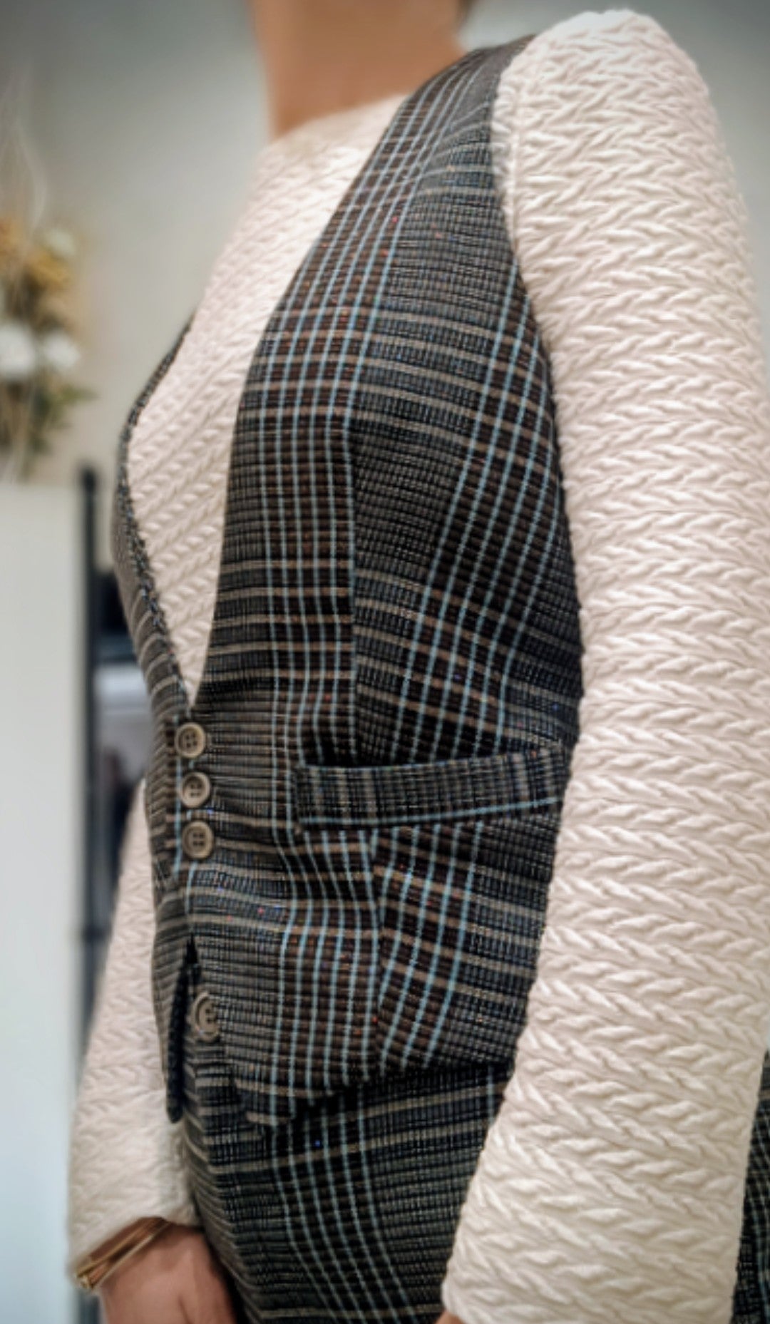 Dettaglio taschine e asole ricamate a mano del gilet a quadri